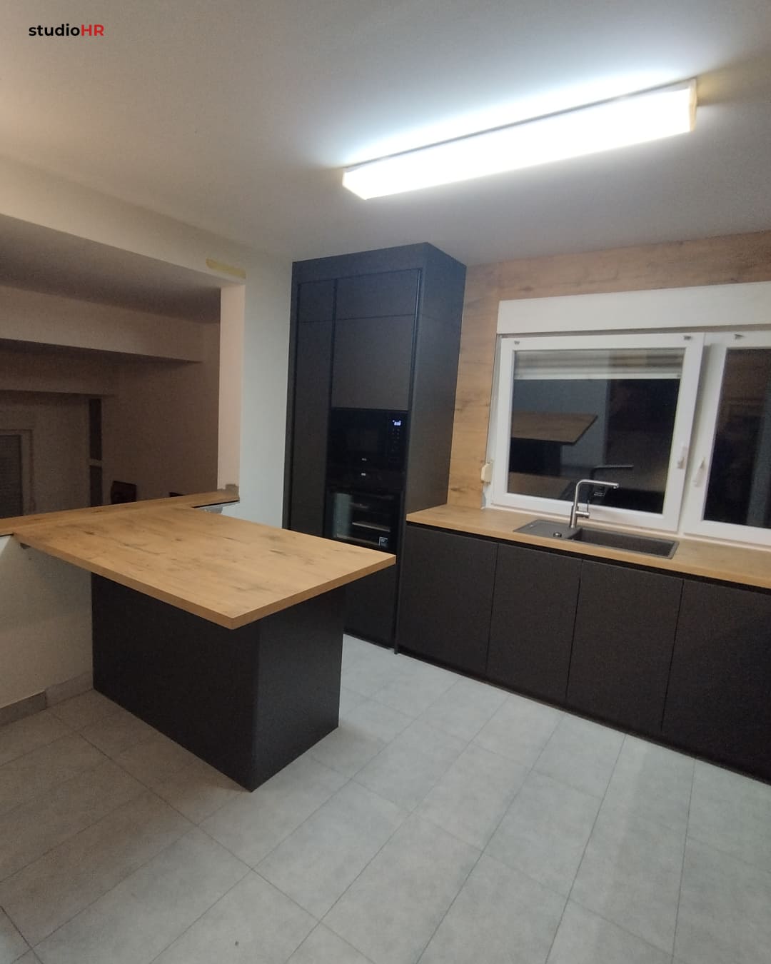 DanKüchen Silbermond kuhinja po mjeri s drvenim pultom i tamnim ugradbenim elementima