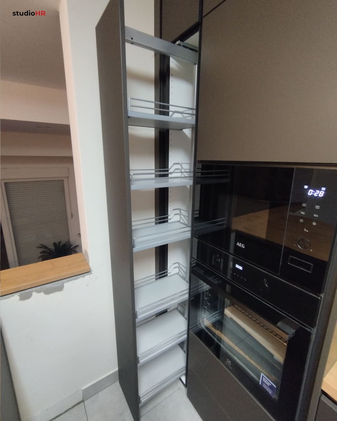 Izvlačni ormarić DanKuchen Silbermond kuhinje s višeslojnim policama pored ugradbene pećnice