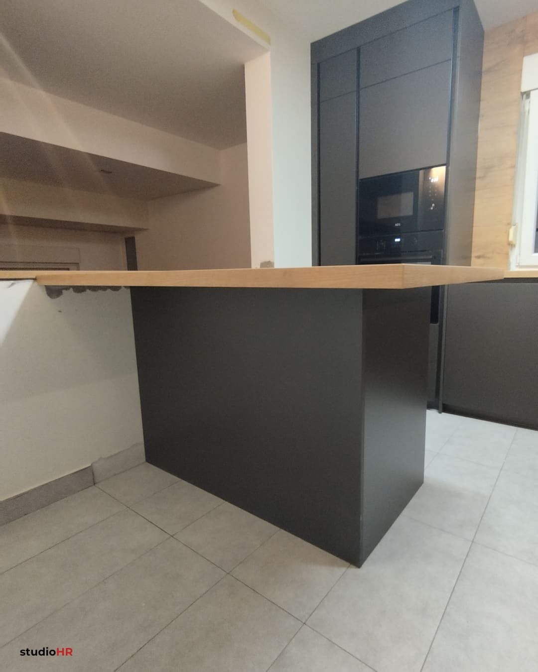 Drveni kuhinjski pult na tamnoj konzoli u DanKuchen Silbermond kuhinji