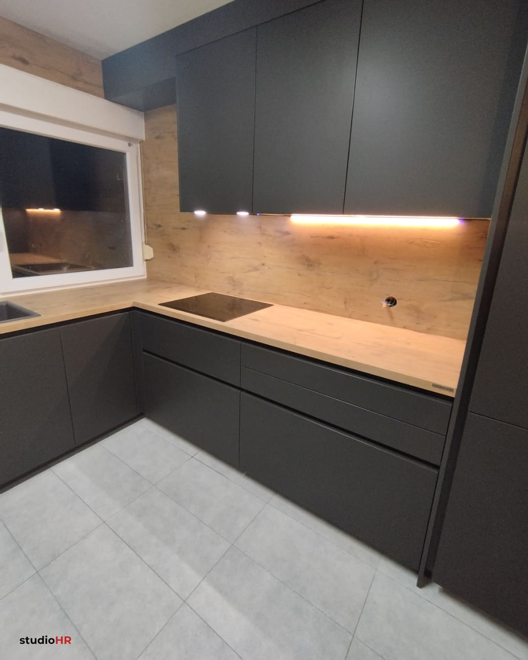 Ugradbena DanKuchen Silbermond kuhinja u tamnosivoj boji s drvenom radnom plohom i LED rasvjetom